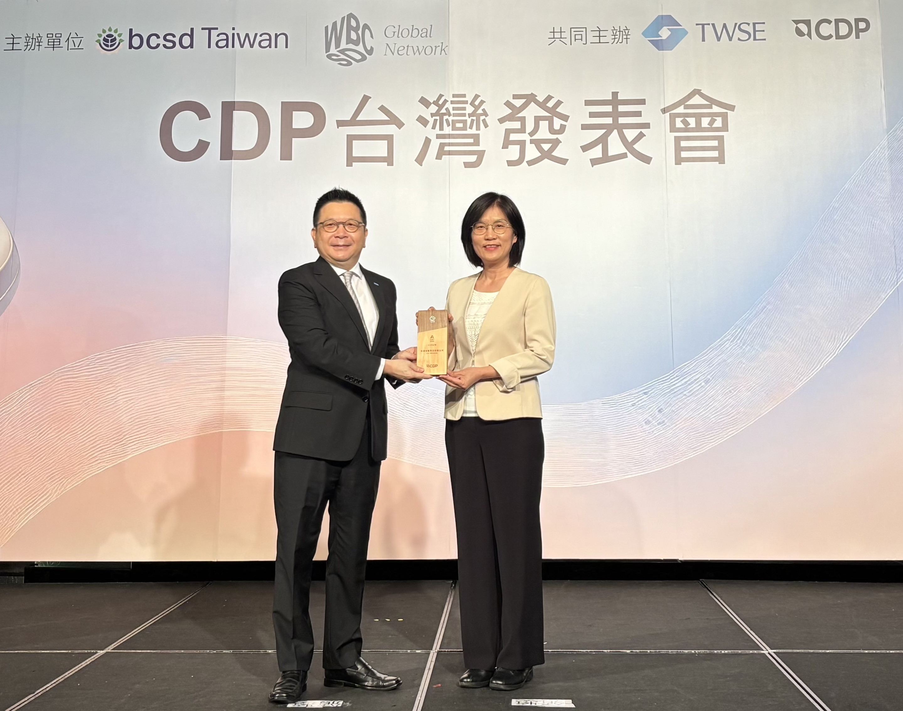 友達永續成果再獲國際評比肯定，獲頒CDP氣候與水資源雙項領導力評級。今由臺灣證券交易所董事長林修銘（左）頒獎，友達光電永續長古秀華（右）代表受獎